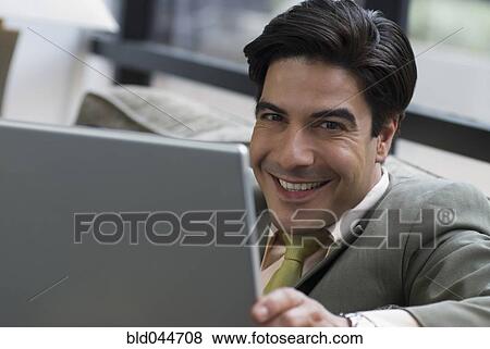 Stock Photo - Hispanic businessman holding laptop. Fotosearch