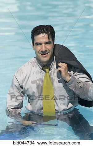 Picture - Hispanic businessman in swimming pool. Fotosearch