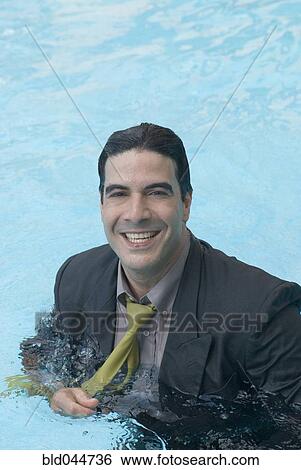 Stock Photograph - Hispanic businessman in swimming pool. Fotosearch