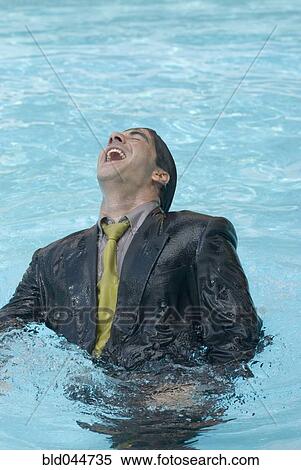 Stock Photography - Hispanic businessman in swimming pool. Fotosearch