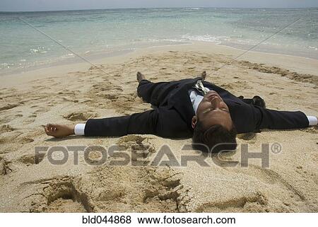 Hispanic businessman laying on beach View Large Photo Image Stock Photo - Hispanic businessman laying on beach. Fotosearch