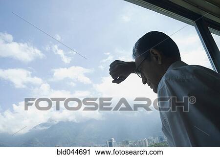 Hispanic businessman looking out window View Large Photo Image Stock Image - Hispanic businessman looking out window. Fotosearch
