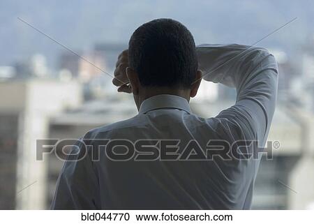 Hispanic businessman looking out window View Large Photo Image Stock Image - Hispanic businessman looking out window. Fotosearch