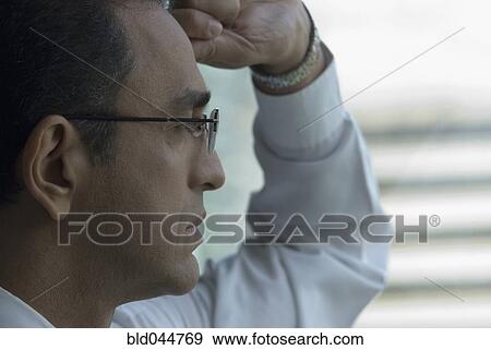 Hispanic businessman looking out window View Large Photo Image Stock Photo - Hispanic businessman looking out window. Fotosearch