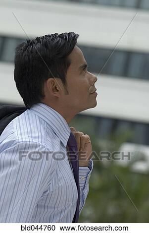 Stock Image - Hispanic businessman looking up. Fotosearch