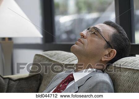 Stock Image - Hispanic businessman on sofa. Fotosearch