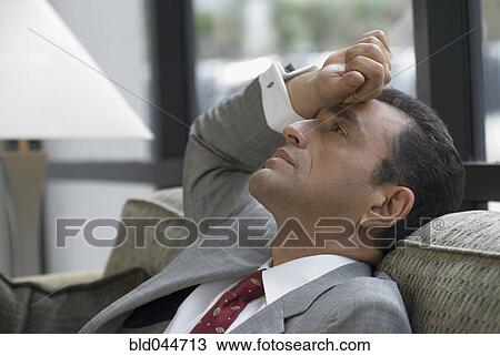 Stock Image - Hispanic businessman on sofa. Fotosearch