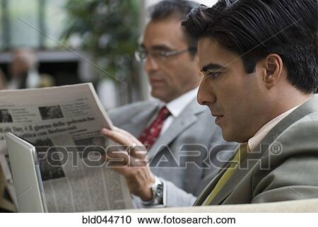 Stock Image - Hispanic businessman reading newspaper. Fotosearch