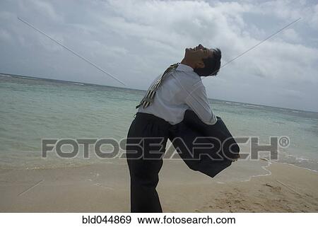 Stock Photo - Hispanic businessman taking off jacket. Fotosearch