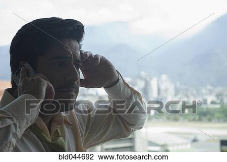 Stock Image - Hispanic businessman talking on cell phone. Fotosearch