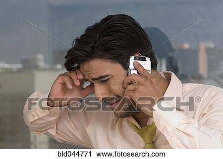 Stock Image - Hispanic businessman talking on cell phone. Fotosearch