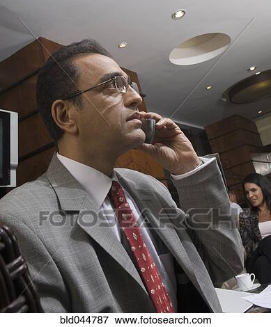 Stock Photo - Hispanic businessman talking on cell phone. Fotosearch