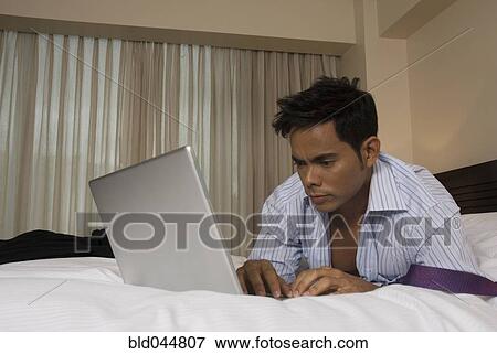 Stock Photo - Hispanic businessman typing on laptop. Fotosearch