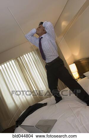 Picture - Hispanic businessman with hands on head. Fotosearch