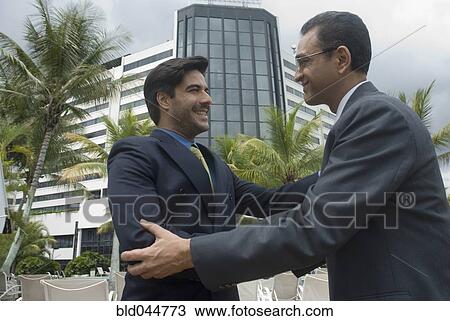 Stock Image - Hispanic businessmen shaking hands. Fotosearch