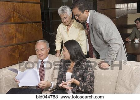 Stock Photo - Hispanic businesspeople discussing paperwork. Fotosearch