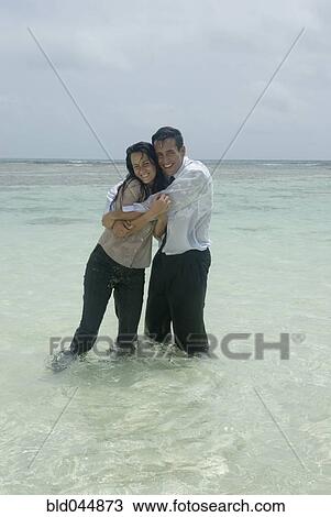 Hispanic businesspeople hugging in water View Large Photo Image Stock Image - Hispanic businesspeople hugging in water. Fotosearch