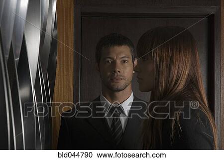 Stock Image - Hispanic businesspeople next to wall. Fotosearch