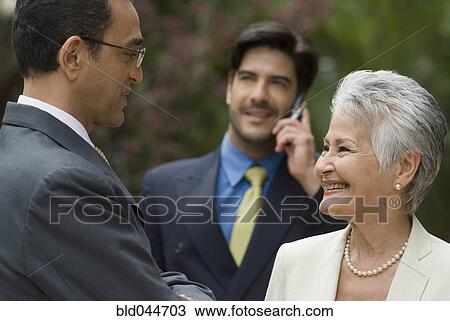 Stock Image - Hispanic businesspeople talking. Fotosearch