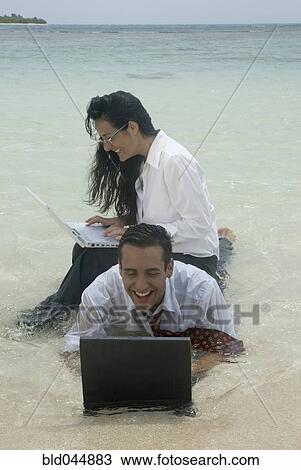 Stock Image - Hispanic businesspeople working in water. Fotosearch