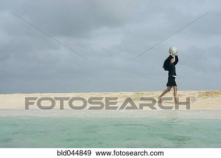 Stock Photo - Hispanic businesswoman holding beach ball. Fotosearch