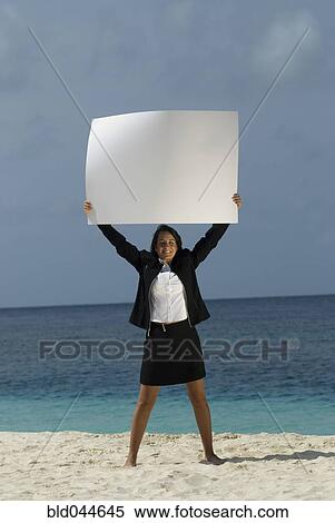 Stock Photography - Hispanic businesswoman holding blank sign. Fotosearch