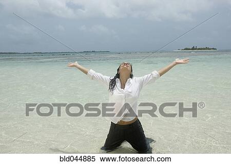 Hispanic businesswoman kneeling in water View Large Photo Image Stock Photography - Hispanic businesswoman kneeling in water. Fotosearch