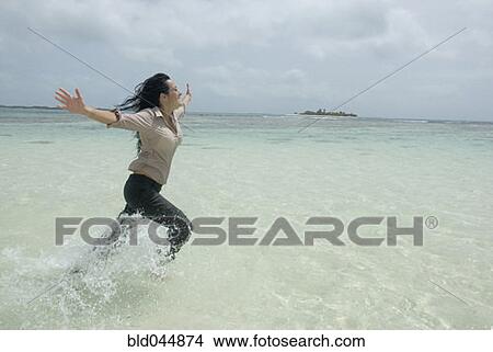 Hispanic businesswoman running in water View Large Photo Image Picture - Hispanic businesswoman running in water. Fotosearch