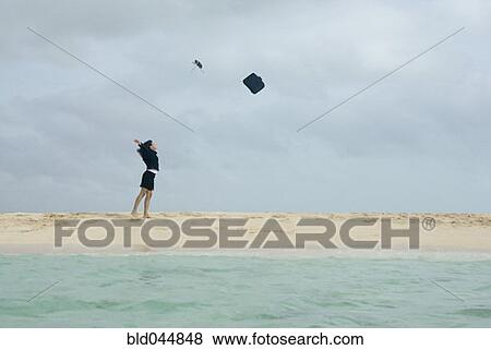 Stock Photo - Hispanic businesswoman throwing briefcase in air. Fotosearch