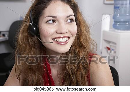 Stock Photography - Hispanic businesswoman wearing headset. Fotosearch