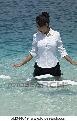 Stock Photo - Hispanic businesswoman with papers in water. Fotosearch