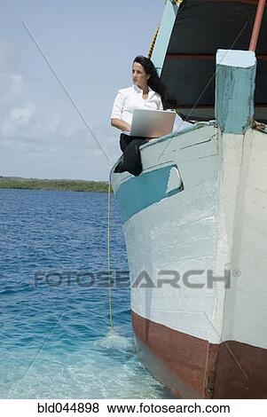 Stock Photo - Hispanic businesswoman working on boat. Fotosearch