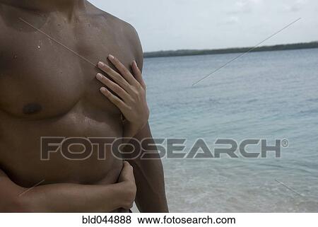 Stock Photo - Hispanic couple hugging at beach. Fotosearch