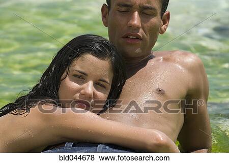 Hispanic couple laying on rock in water View Large Photo Image Stock Photo - Hispanic couple laying on rock in water. Fotosearch