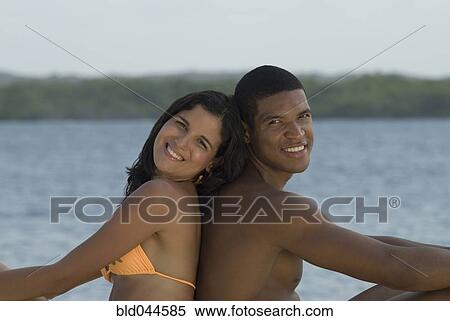 Stock Photography - Hispanic couple sitting back to back. Fotosearch