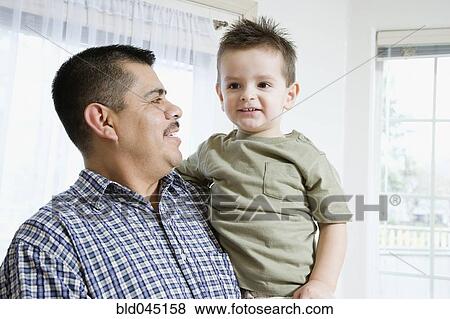 Stock Photo - Hispanic father and son hugging. Fotosearch