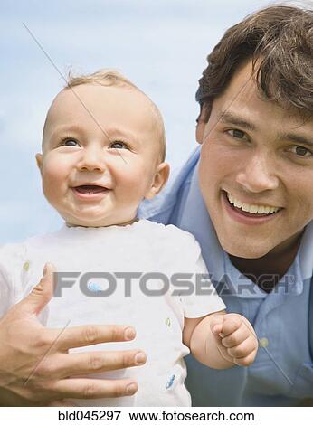 Hispanic father holding baby View Large Photo Image Stock Photo - Hispanic father holding baby. Fotosearch