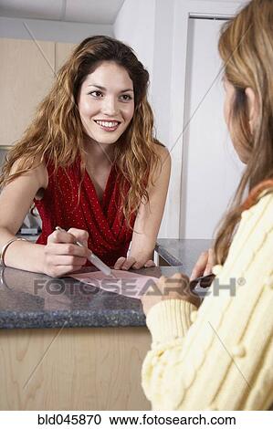 Stock Image - Hispanic female medical professional helping patient. Fotosearch