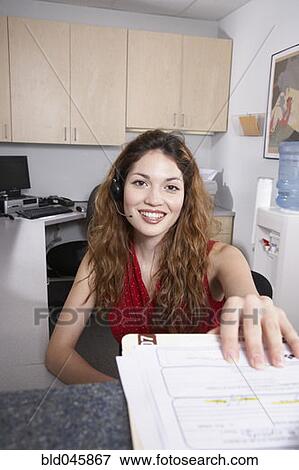 Stock Photo - Hispanic female medical professional taking chart. Fotosearch