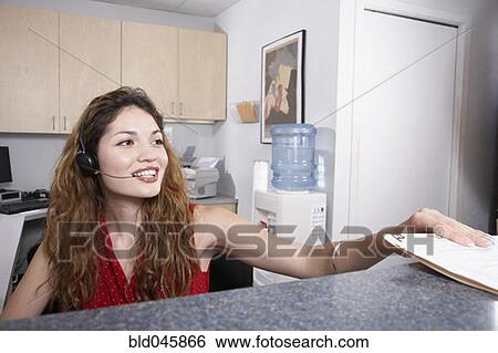 Stock Photograph - Hispanic female medical professional taking chart. Fotosearch