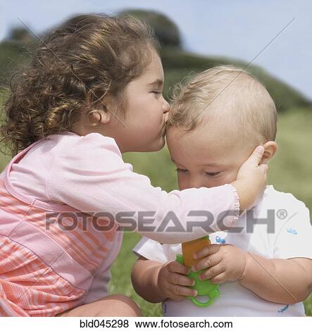 Stock Photo - Hispanic girl kissing baby. Fotosearch