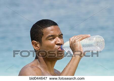 Hispanic man drinking water bottle View Large Photo Image Stock Photo - Hispanic man drinking water bottle. Fotosearch