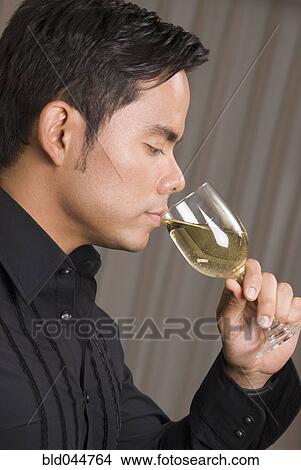 Picture - Hispanic man drinking wine. Fotosearch
