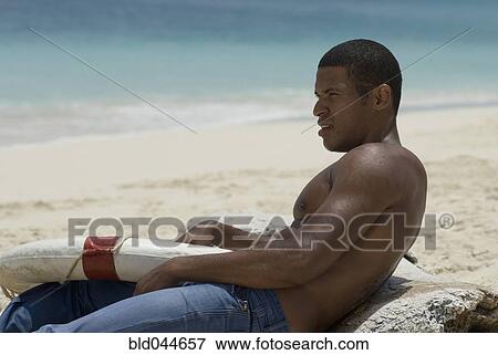 Hispanic man holding life preserver at beach View Large Photo Image Stock Photo - Hispanic man holding life preserver at beach. Fotosearch