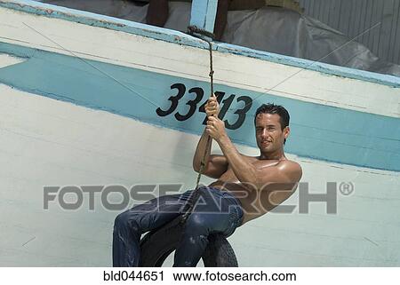 Hispanic man in tire swing on boat View Large Photo Image Stock Image - Hispanic man in tire swing on boat. Fotosearch