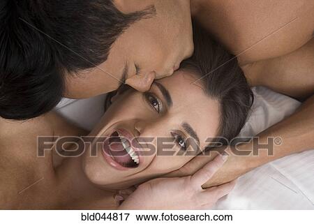 Stock Photo - Hispanic man kissing girlfriend on head. Fotosearch