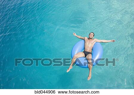 Hispanic man on float in water View Large Photo Image Stock Photograph - Hispanic man on float in water. Fotosearch
