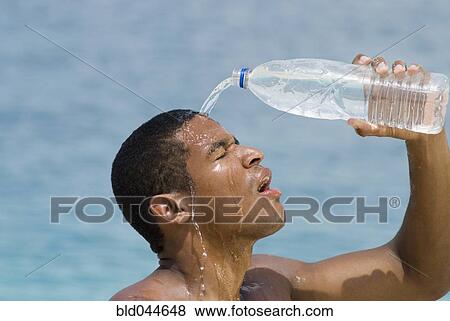 Stock Photo - Hispanic man pouring water over head. Fotosearch