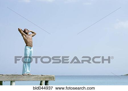 Stock Photo - Hispanic man standing on dock. Fotosearch