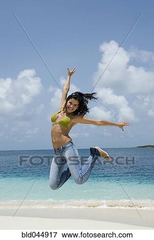Hispanic woman jumping at beach View Large Photo Image Stock Photo - Hispanic woman jumping at beach. Fotosearch